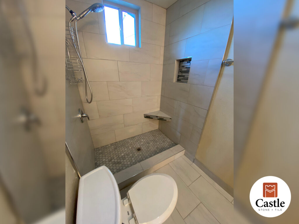 Castle Stone & Tile installed 12x24 porcelain tile with Schluter trim in a Lakeside bathroom. The result is a sleek, modern space with clean lines and durable finishes.