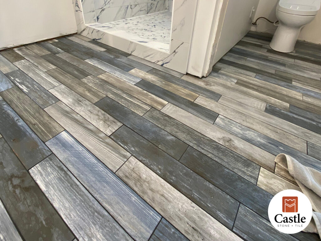 Castle Stone & Tile installed porcelain wood-look planks in a Jamul bathroom and laundry. The multi-tone finish delivers the warmth of hardwood with the durability of porcelain.